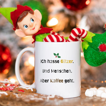 Lustige Anti-Weihnachten Tasse aus Keramik mit schwarzem Schriftzug „Ich hasse Glitzer. Und Menschen. Aber Kaffee geht.“ – originelles Weihnachtsgeschenk für Kaffee-Liebhaber, Weihnachtsmuffel und Kolleginnen mit trockenem Humor. Perfekt als witzige Nikolausidee, Geschenk für die Kollegin, Glühweintasse, witziges Wichtelgeschenk oder kleine Geschenkidee zu Weihnachten. Für alle, die Weihnachten nicht feiern, aber Kaffee lieben – ideal als Becher für Büro, Homeoffice oder Adventskalender.