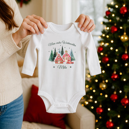 Babybody „Mein erstes Weihnachten“ mit nostalgischem Weihnachtsdorf-Motiv: zwei rote Häuser, verschneite Tannen und ein Vintage-Auto mit Weihnachtsbaum. Inklusive personalisiertem Namen (z. B. Luisa) unter dem Design. Aus 100 % Bio-Baumwolle, in Kurzarm oder Langarm erhältlich. Ideal als Geschenk zur Wintergeburt oder fürs erste Weihnachtsfest. Perfekt für Erinnerungsfotos, Familienfeiern oder Partnerlook mit Mama und Papa. Zauberhaftes Baby-Outfit für Weihnachten 2025.
