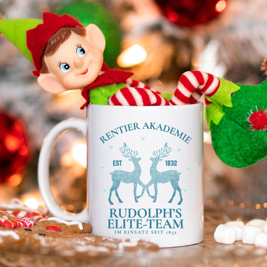 Lustige Weihnachtstasse mit Rentier-Motiv „Rentier Akademie – Rudolph’s Elite-Team“ in winterlichem Design. Geschenkidee für Weihnachten, ideal für Familie, Freunde, Kollegen. Perfekt für Kaffee, Tee, Glühwein oder heiße Schokolade. Spülmaschinenfest, mikrowellengeeignet & beidseitig bedruckt. Winterbecher mit Schneeflocken & Rentieren – ideal als Wichtelgeschenk, Weihnachtsgeschenk, Nikolausüberraschung oder fürs Büro. Hochwertiger Druck, nachhaltige Produktion in Deutschland. Weihnachtstasse