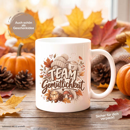 Herbst Tasse mit Spruch „Team Gemütlichkeit“ als gemütliches Herbst Geschenk, Me Time Geschenk und Geschenk für beste Freundin. Weiße Keramiktasse 330 ml beidseitig bedruckt mit herbstlichem Cozy-Season-Motiv aus warmer Tasse, Strickmütze, Kuscheldecke, Kerze, Pilzen, Tannenzapfen, Eicheln und Herbstblättern. Herbsttasse für Herbstzeit und gemütliche Kaffee-, Tee- oder Kakaomomente, ideal als Geschenk für Kaffeeliebhaber, Freundin, Mama, Schwester und echte Herbstfans.