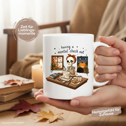 Halloween Tasse mit Spruch „having a mental check out“ und lustigem Skelett am Schreibtisch als Halloween Geschenk und Geschenk für Freundin oder Kollegin. Weiße Keramiktasse 330 ml beidseitig bedruckt mit Skelett, Kalender, Kaffee, Keksen, schwarzer Katze, Kürbis und Herbstblättern. Humorvolle Skelett Tasse für Spooky Season und Herbstzeit, ideal als lustiges Geschenk für Halloweenfans, beste Freundin, Schwester und Kollegin. Halloween Tasse, Mental Load Tasse, Lustige Tasse Kollegin