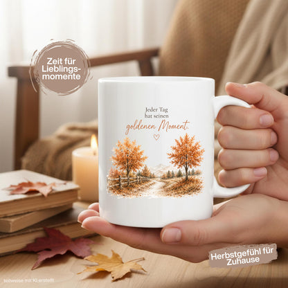Herbst Tasse mit Spruch „Jeder Tag hat seinen goldenen Moment“ als Geschenk für beste Freundin und Geschenk für Kaffeeliebhaber. Weiße Keramiktasse 330 ml beidseitig bedruckt mit herbstlicher Landschaft, goldenen Bäumen und warmen Naturfarben. Herbsttasse für Herbstzeit und Cozy Season, Kaffeeliebhaber Geschenk, Herbst Geschenk, Selfcare Geschenk und Me Time Geschenk für Freundin, Mama oder Schwester. Keramiktasse mit Produktion und Versand aus Deutschland.  geschenk beste freundin, Herbsttasse