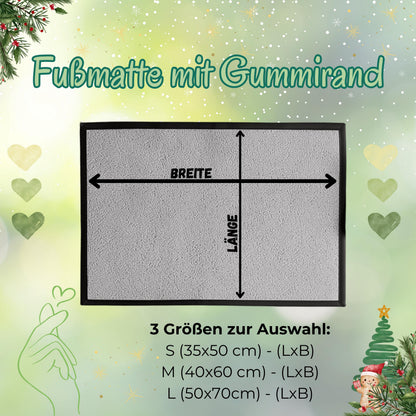 Größenübersicht „Fußmatte mit Gummirand“ für die personalisierte Weihnachtsfußmatte mit Wintertieren. Eine rechteckige, unbedruckte graue Matte mit schwarzem Rand zeigt Pfeile für Breite und Länge. Darunter sind die drei wählbaren Formate aufgeführt: S mit 35 × 50 cm, M mit 40 × 60 cm und L mit 50 × 70 cm. Die hellgrüne Grafik ist mit Herzen, Schneeflocken, Sternen, Tannenzweigen und einem Weihnachtsbaum gestaltet. Maßhilfe zur Auswahl einer passenden Schmutzfangmatte für Haustür und Eingangsbereich.