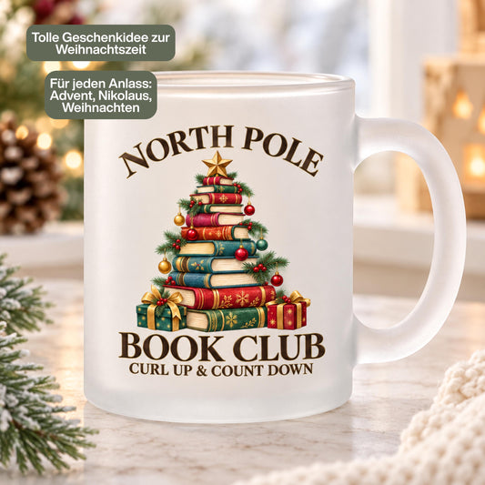 Diese Weihnachtstasse zeigt einen Weihnachtsbaum aus gestapelten Büchern mit dem Schriftzug 'North Pole Book Club – Curl Up & Count Down' im Vintage-Gold-Rot-Grün-Design. Als Weihnachtsbecher aus satiniertem Glas mit 300 ml Fassungsvermögen eignet sie sich perfekt als Weihnachtsgeschenk, Wichtelgeschenk oder Nikolaus Tasse für Bücherfans. Eine liebevolle Kaffeetasse Weihnachten für Kaffee, Tee, Kakao und Glühwein, ideal als Winter Tasse für gemütliche Lesestunden