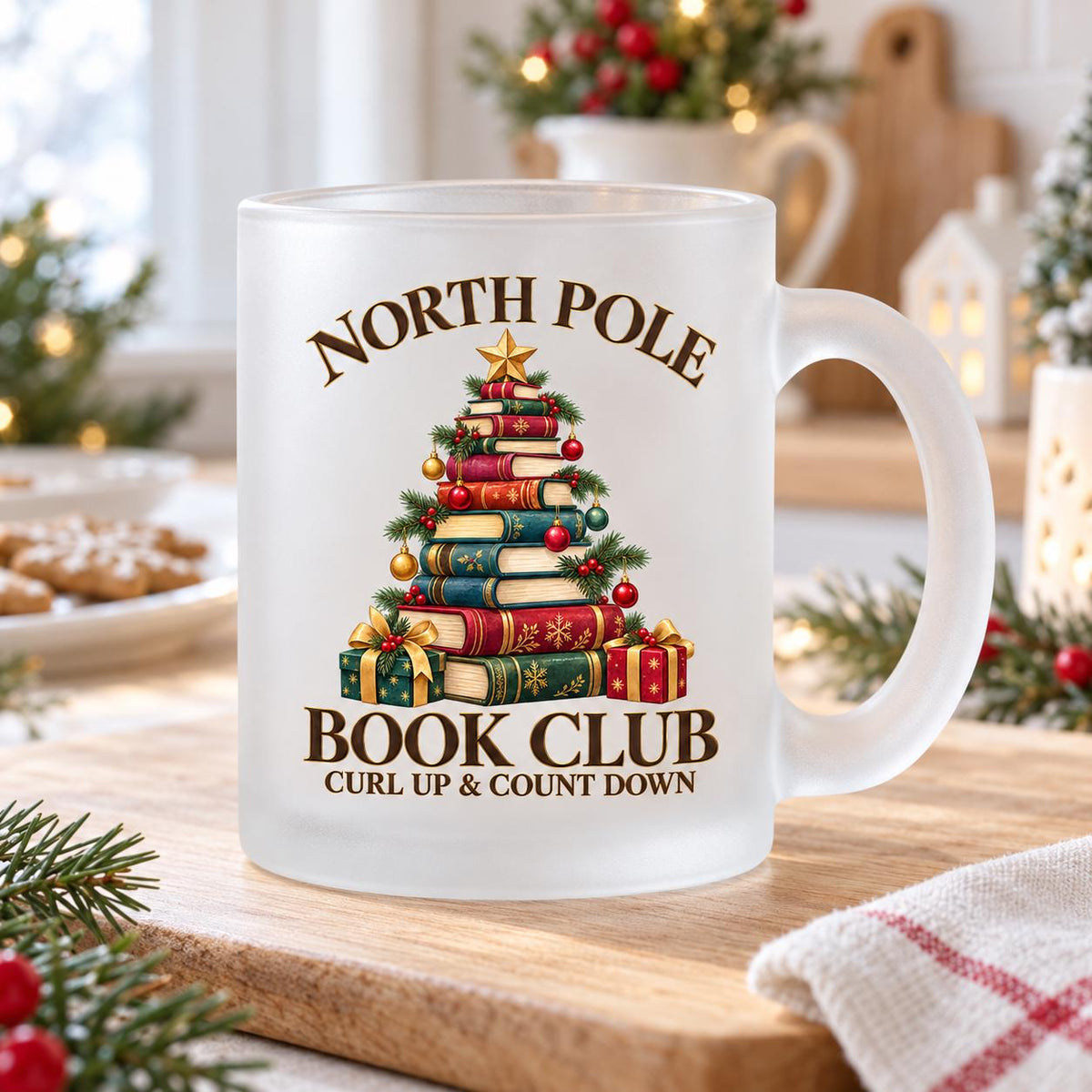 Diese Weihnachtstasse zeigt einen Weihnachtsbaum aus gestapelten Büchern mit dem Schriftzug 'North Pole Book Club – Curl Up & Count Down' im Vintage-Gold-Rot-Grün-Design. Als Weihnachtsbecher aus satiniertem Glas mit 300 ml Fassungsvermögen eignet sie sich perfekt als Weihnachtsgeschenk, Wichtelgeschenk oder Nikolaus Tasse für Bücherfans. Eine liebevolle Kaffeetasse Weihnachten für Kaffee, Tee, Kakao und Glühwein, ideal als Winter Tasse für gemütliche Lesestunden