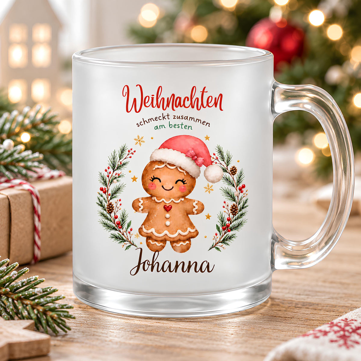 Personalisierte Weihnachtstasse mit einer Lebkuchenfigur mit roter Schleife, präsentiert vor einer festlichen Kulisse mit Tannenzweigen und Weihnachtslichtern. Die Lebkuchenmotive sind von einem Tannenkranz mit Zapfen, Beeren und goldenen Sternen umrahmt und tragen „Weihnachten schmeckt zusammen am besten“. Die satinierte 300-ml-Glastasse wird beidseitig mit Wunschname bedruckt. Persönliches Weihnachtsgeschenk für Familie, Freunde oder Kollegen, auch zu Nikolaus oder zum Wichteln. Für Kaffee, Tee und Kakao.