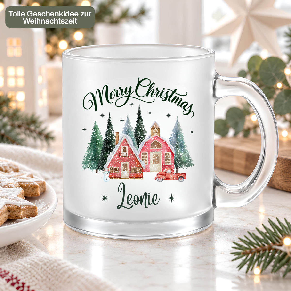 Personalisierte Weihnachtstasse mit Namen Leonie, Merry Christmas Schriftzug und rotem Weihnachtsdorf auf satiniertem Glas. Der Weihnachtsbecher mit transparentem Henkel wird als Geschenkidee zur Weihnachtszeit präsentiert. Individuelle Tasse mit Wunschname für Kaffee, Tee, Kakao oder Glühwein, mit ca. 300 ml Fassungsvermögen. Ein persönliches Weihnachtsgeschenk für Mama, Oma, Schwester oder die beste Freundin, auch als Aufmerksamkeit zum Nikolaus oder als Wichtelgeschenk in der Adventszeit. Höhe ca. 95 mm.