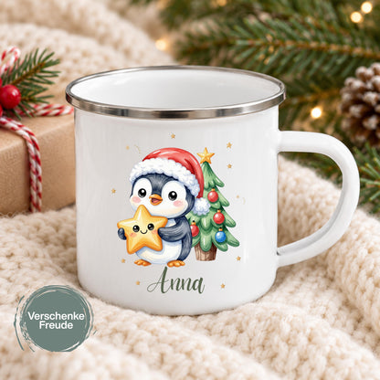 Personalisierte Weihnachtstasse für Kinder aus weißer Emaille mit silberfarbenem Rand und weißem Henkel. Die Kindertasse wird mit Wunschname und ausgewähltem Weihnachtsmotiv bedruckt. Ein persönlicher Kinderbecher als Weihnachtsgeschenk oder Nikolausgeschenk für Kinder, Enkelkinder und Patenkinder. Zur Auswahl stehen Hase, Pinguin, Eisbär, Bär, Rentiere und Igel. Geliefert wird eine Tasse im gewählten Design. Pinguin mit Weihnachtsmütze hält einen Stern neben dem Tannenbaum.