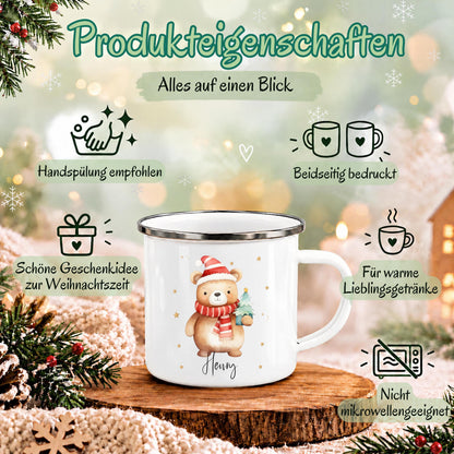 Personalisierte Weihnachtstasse für Kinder aus weißer Emaille mit silberfarbenem Rand und weißem Henkel. Das Motiv zeigt einen braunen Weihnachtsbären mit roter Weihnachtsmütze, rot-weiß gestreiftem Schal und einem grünen Tannenbaum im Arm. Unter dem Bären steht ein Beispielname; die Kindertasse wird mit Wunschname bedruckt. Weihnachtsbecher für Bärenfans und eine Geschenkidee zu Weihnachten oder Nikolaus für Kinder, Enkelkinder und Patenkinder. Infografik zu den Produkteigenschaften.