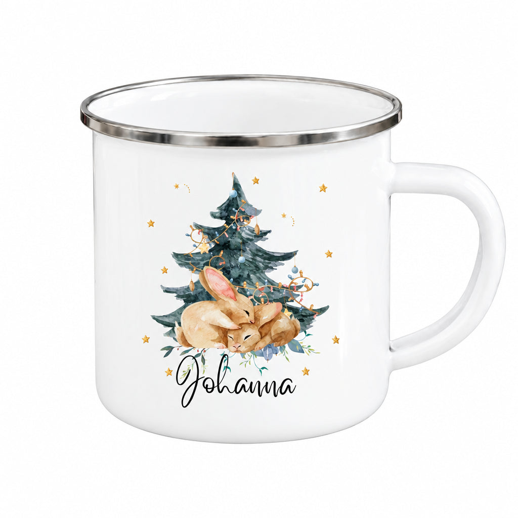 Personalisierte Weihnachtstasse für Kinder aus weißer Emaille mit silberfarbenem Rand und weißem Henkel. Das Hasenmotiv zeigt zwei braune Hasen unter einem geschmückten Weihnachtsbaum. Unter der winterlichen Illustration steht ein Beispielname; die Kindertasse wird mit Wunschname bedruckt. Persönlicher Weihnachtsbecher für kleine Hasenfans und eine Geschenkidee zu Weihnachten oder Nikolaus für Kinder, Enkelkinder und Patenkinder. Nahansicht von Hasenmotiv und Namensdruck.