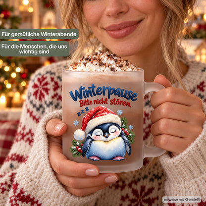 Diese Tasse Weihnachten zeigt einen schlafenden Pinguin mit Nikolausmütze und den Spruch 'Winterpause: Bitte nicht stören', umgeben von Tannenzweigen und Schneeflocken. Als Weihnachtsbecher aus satiniertem Glas mit 300 ml Fassungsvermögen eignet sie sich perfekt als Weihnachtsgeschenk, Wichtelgeschenk oder Nikolaus Tasse. Eine humorvolle Kaffeetasse Weihnachten für Kaffee, Tee, Kakao und Glühwein, ideal als Winter Tasse für alle, die den Winter am liebsten verschlafen würden.