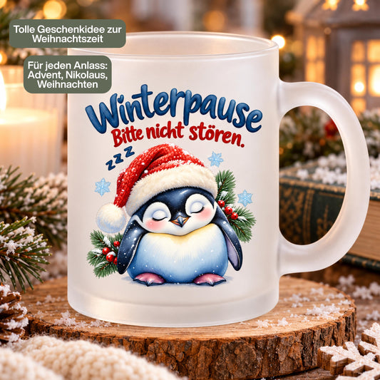 Diese Tasse Weihnachten zeigt einen schlafenden Pinguin mit Nikolausmütze und den Spruch 'Winterpause: Bitte nicht stören', umgeben von Tannenzweigen und Schneeflocken. Als Weihnachtsbecher aus satiniertem Glas mit 300 ml Fassungsvermögen eignet sie sich perfekt als Weihnachtsgeschenk, Wichtelgeschenk oder Nikolaus Tasse. Eine humorvolle Kaffeetasse Weihnachten für Kaffee, Tee, Kakao und Glühwein, ideal als Winter Tasse für alle, die den Winter am liebsten verschlafen würden.