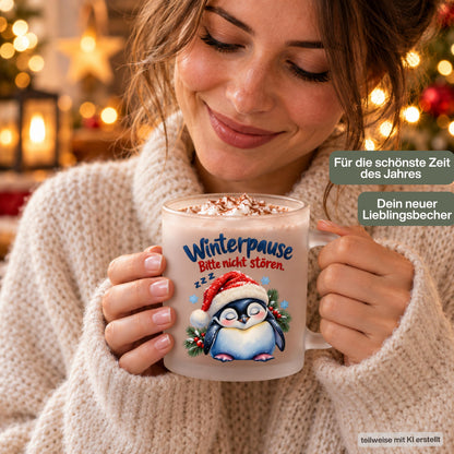 Diese Tasse Weihnachten zeigt einen schlafenden Pinguin mit Nikolausmütze und den Spruch 'Winterpause: Bitte nicht stören', umgeben von Tannenzweigen und Schneeflocken. Als Weihnachtsbecher aus satiniertem Glas mit 300 ml Fassungsvermögen eignet sie sich perfekt als Weihnachtsgeschenk, Wichtelgeschenk oder Nikolaus Tasse. Eine humorvolle Kaffeetasse Weihnachten für Kaffee, Tee, Kakao und Glühwein, ideal als Winter Tasse für alle, die den Winter am liebsten verschlafen würden.