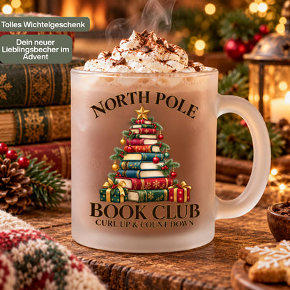 Diese Weihnachtstasse zeigt einen Weihnachtsbaum aus gestapelten Büchern mit dem Schriftzug 'North Pole Book Club – Curl Up & Count Down' im Vintage-Gold-Rot-Grün-Design. Als Weihnachtsbecher aus satiniertem Glas mit 300 ml Fassungsvermögen eignet sie sich perfekt als Weihnachtsgeschenk, Wichtelgeschenk oder Nikolaus Tasse für Bücherfans. Eine liebevolle Kaffeetasse Weihnachten für Kaffee, Tee, Kakao und Glühwein, ideal als Winter Tasse für gemütliche Lesestunden