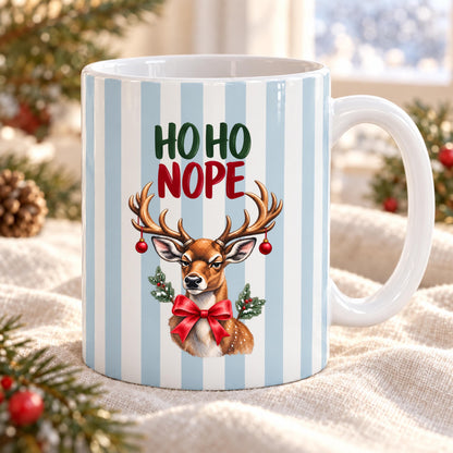 Lustige Weihnachtstasse mit Anti Weihnachten Spruch „Ho Ho Nope" zeigt diese Keramiktasse Weihnachten in drei Farben: Beige, Grün und Blau, jeweils mit feinem Streifendesign. Auf jeder Kaffeetasse Weihnachten blickt ein skeptisches Rentier mit rotem Schleifchen und Christbaumkugeln im Geweih. Diese lustige Weihnachtstasse mit Anti Weihnachten Sprüche eignet sich als Wichtelgeschenk Tasse, Weihnachtsgeschenk Tasse oder Weihnachtsbecher Geschenk für alle mit Humor zur Adventszeit.
