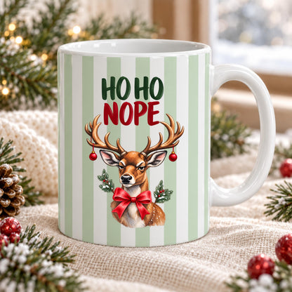 Lustige Weihnachtstasse mit Anti Weihnachten Spruch „Ho Ho Nope" zeigt diese Keramiktasse Weihnachten in drei Farben: Beige, Grün und Blau, jeweils mit feinem Streifendesign. Auf jeder Kaffeetasse Weihnachten blickt ein skeptisches Rentier mit rotem Schleifchen und Christbaumkugeln im Geweih. Diese lustige Weihnachtstasse mit Anti Weihnachten Sprüche eignet sich als Wichtelgeschenk Tasse, Weihnachtsgeschenk Tasse oder Weihnachtsbecher Geschenk für alle mit Humor zur Adventszeit.