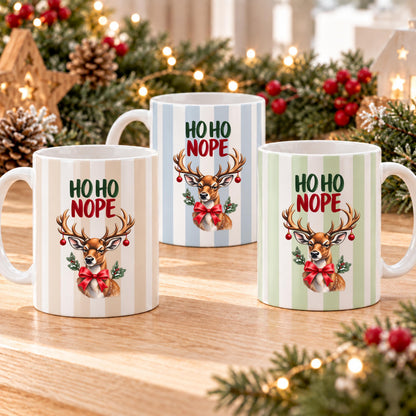 Lustige Weihnachtstasse mit Anti Weihnachten Spruch „Ho Ho Nope" zeigt diese Keramiktasse Weihnachten in drei Farben, jeweils mit feinem Streifendesign. Auf jeder Kaffeetasse Weihnachten blickt ein skeptisches Rentier mit rotem Schleifchen und Christbaumkugeln im Geweih. Diese lustige Weihnachtstasse mit Anti Weihnachten Sprüche eignet sich als Wichtelgeschenk Tasse, Weihnachtsgeschenk Tasse oder Weihnachtsbecher Geschenk für alle mit Humor zur Adventszeit. Anti Weihnachten Sprüche