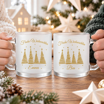 Personalisierte Weihnachtstasse mit Namen aus satiniertem, transparentem Glas mit goldener Schrift „Frohe Weihnachten" und vier goldenen Tannenbäumen mit Sternen. Diese Tasse personalisiert wird individuell mit deinem Wunschnamen bedruckt und eignet sich als Weihnachtsgeschenk für Familie, Freunde, Kollegen oder Großeltern. Als besondere Kaffeetasse Weihnachten ist diese Tasse mit Namen ein liebevolles Unikat für die ganze Weihnachtszeit. Paar Tasse, Geschenk Freundin, personalisiertes Gesc