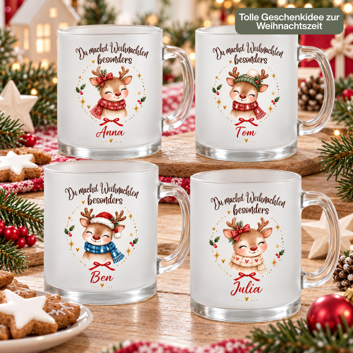 Vier personalisierte Rentier-Weihnachtstassen aus satiniertem Glas mit Namen Anna, Tom, Ben und Julia. Die Rentiere tragen rote oder beige Herzschals, grüne Strickmütze oder Nikolausmütze mit blauem Schal. Über jedem Motiv steht „Du machst Weihnachten besonders“. Die Glastassen mit Glashenkeln stehen auf Holz zwischen Sternplätzchen, Tannengrün, roten Beeren und Kugeln. Rot-weißer Strickstoff, Holzsterne, ein Dekohaus und Lichter begleiten „Tolle Geschenkidee zur Weihnachtszeit“ für Familie und Freunde.
