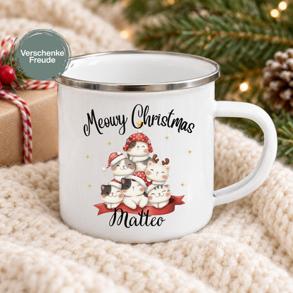 Personalisierte Weihnachtstasse für Kinder aus weißer Emaille mit silberfarbenem Rand und weißem Henkel. Sechs Katzen mit verschiedenen Fellfarben und Weihnachtsaccessoires bilden das Motiv unter dem Schriftzug „Meowy Christmas“. Darunter steht ein Beispielname; die Kindertasse wird mit Wunschname bedruckt. Persönlicher Weihnachtsbecher für Katzenfans und eine Geschenkidee zu Weihnachten oder Nikolaus für Kinder, Enkelkinder und Patenkinder. Frontansicht mit dem Beispielnamen Matteo.